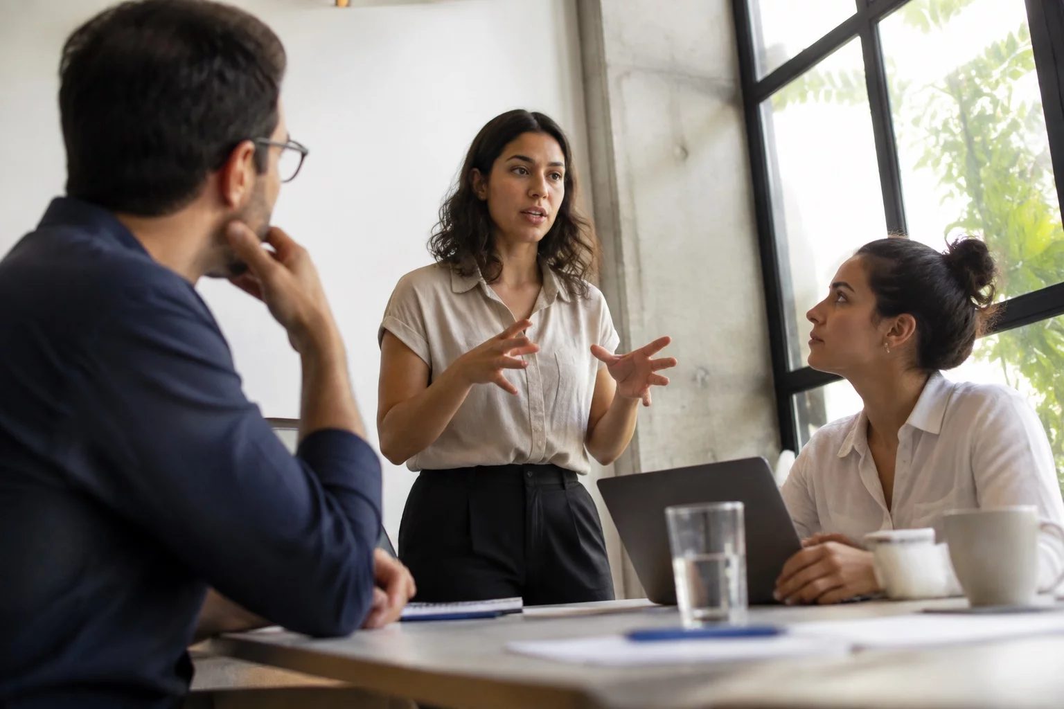Profissionais em uma sala de reunião clara, uma pessoa explicando
